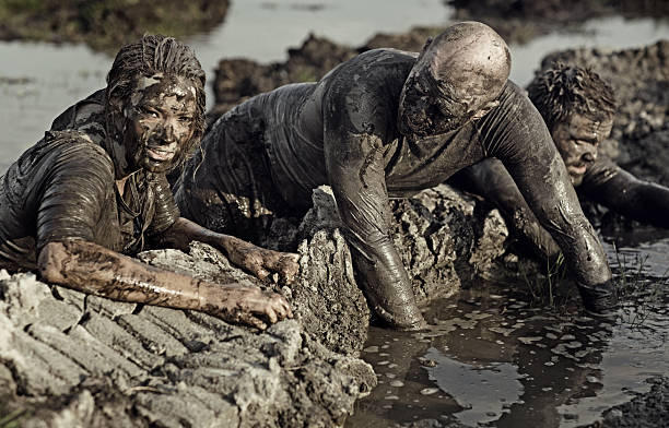 istock group of people crossing mud obstacle 491277426