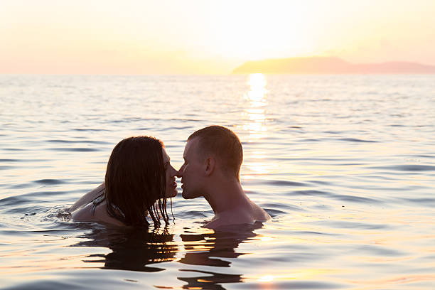 Couple kissing in sea stock photo
