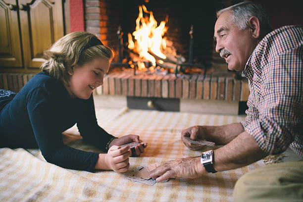 Grandfather and granddaughter playing cards Granddad & granddaughter playing cards family playing card game stock pictures, royalty-free photos & images