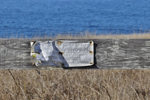 No trespassing sign on a fence to the ocean