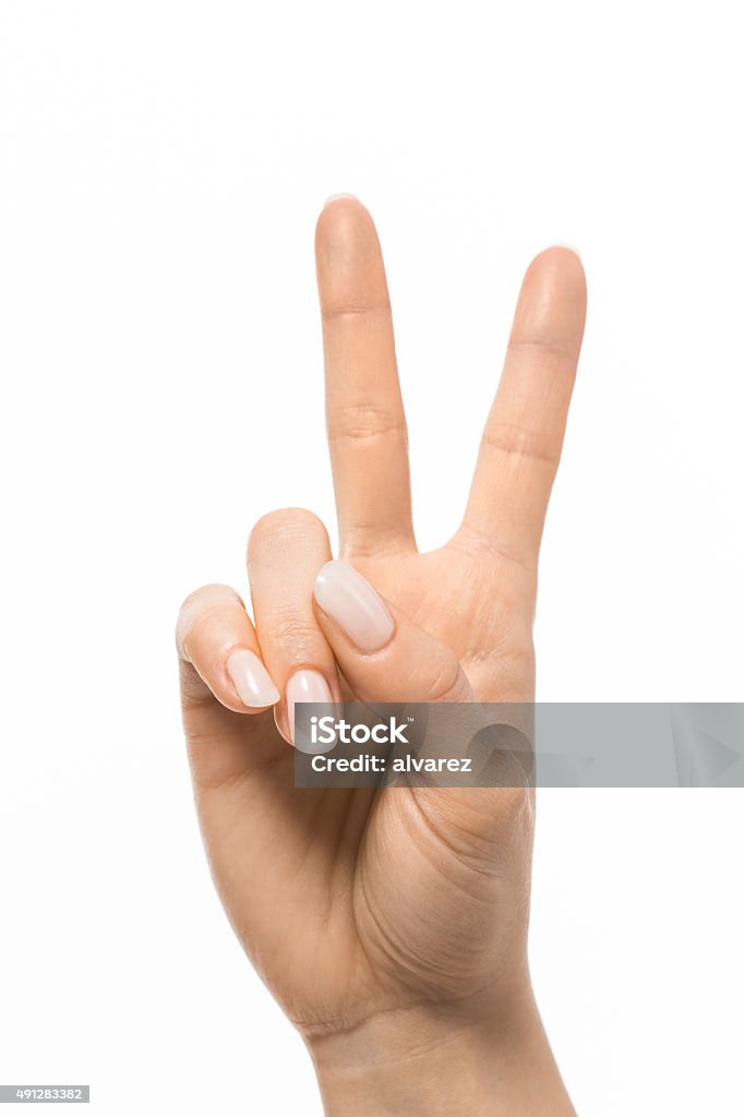 Hand gesturing peace symbol Closeup of hand gesturing peace symbol on white background Peace Sign - Gesture Stock Photo