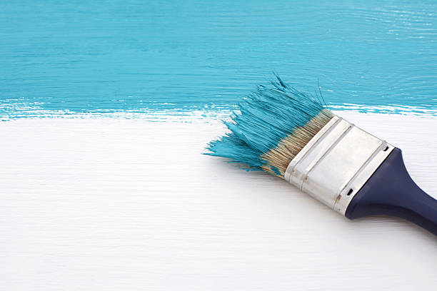 istock Paintbrush with blue paint, painting over white board 491292004