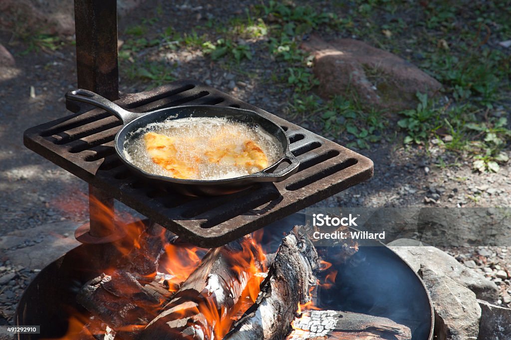 Fish Frying Outdoors In A Cast Iron Pan On Grill Stock Photo