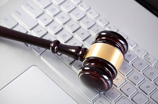 istock Wooden judge hammer on laptop computer white keyboard 491293206