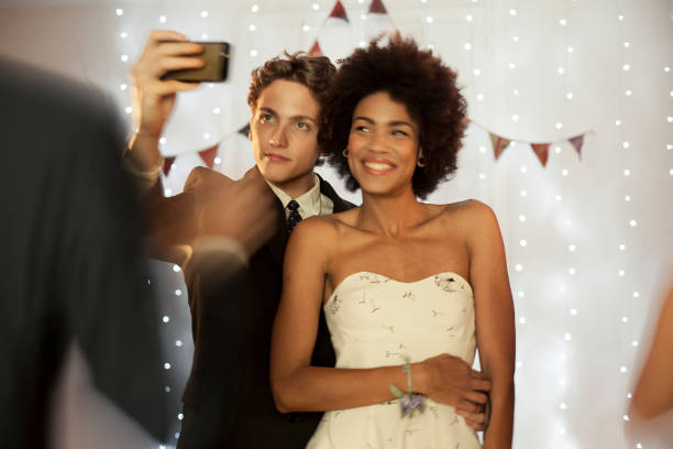 Couple taking a selfie at prom party Couple taking a selfie at prom party prom stock pictures, royalty-free photos & images