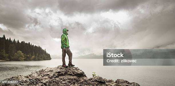 Man Beside A Mountain Lake In Rain Stock Photo - Download Image Now - Hiking, Rain, Mature Men