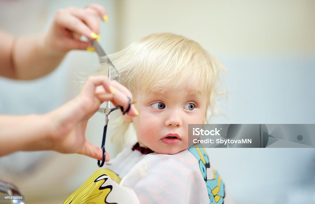 Toddler child getting his first haircut Close up portrait of toddler child getting his first haircut Cutting Hair Stock Photo