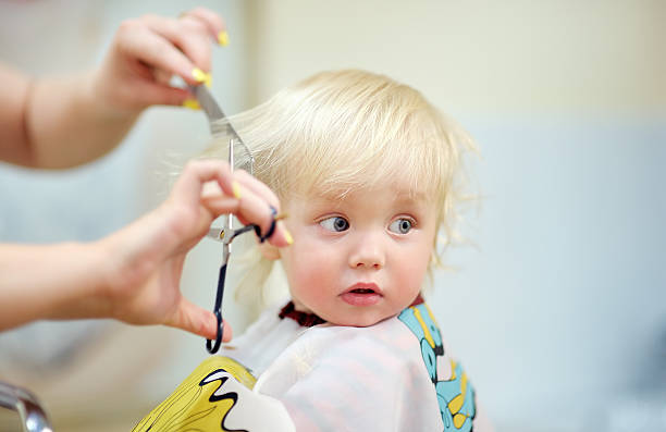 Toddler child getting his first haircut stock photo