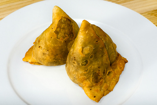 Fried samoosa on a white plate.