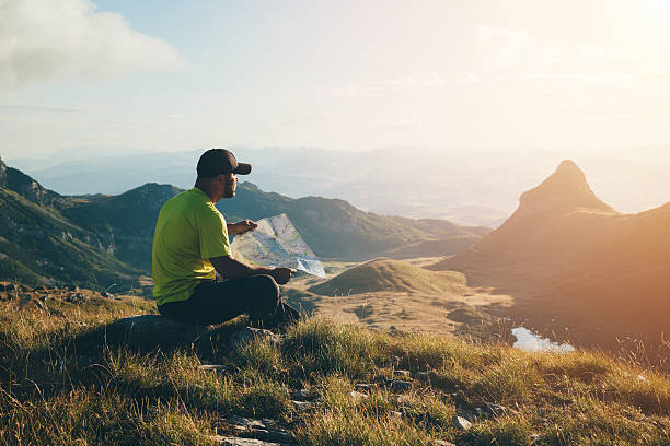 istock Man with a map on top of the mountain. 491316260