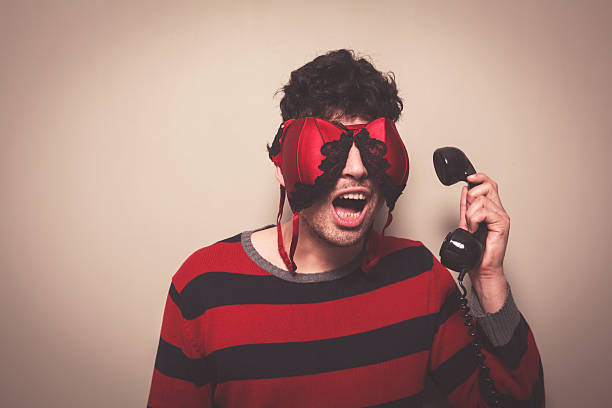 istock Man with bra on face answering telephone 491325231