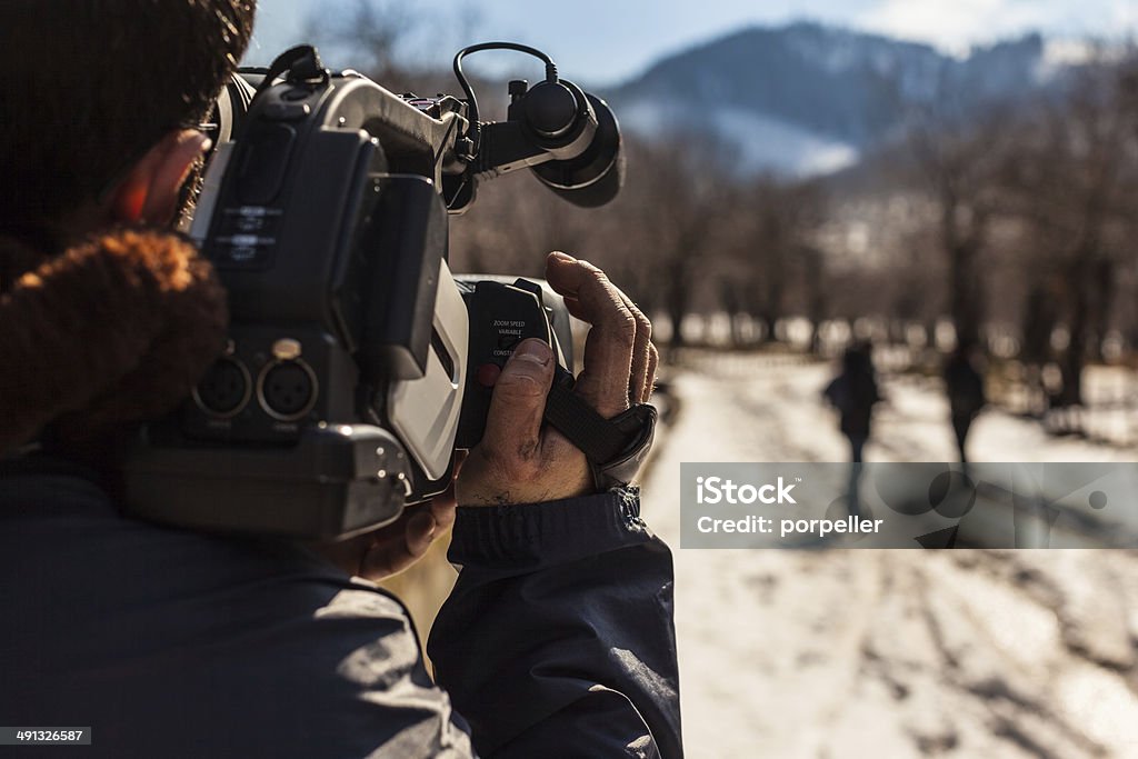 report a young man using a professional camcorder outdoor Reportage Stock Photo
