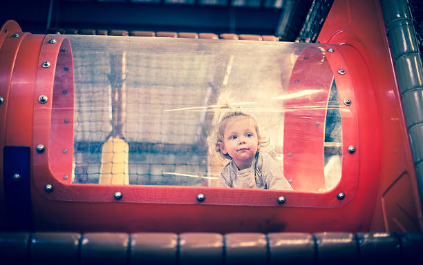 Baby playing inside a toy tunnel stock photo