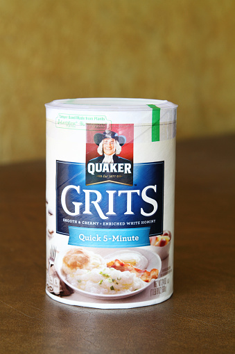 West Palm Beach, USA - August 23, 2015: Product shot of a container of Quaker Grits. The grits are the quick cook type that can be prepared in five minutes. Grits are a product of Quaker Oats Company. Grits are a popular southern USA cuisine product often served with eggs for breaksfast.