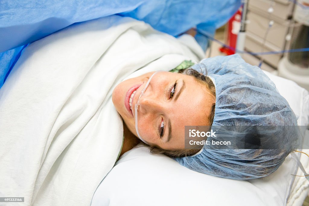 Cesarean Section C-Section Birth Mother and Newborn First look after Cesarean Section C-Section Birth. Mother smiling at view with her Newborn following surgery. Caesarean Section Stock Photo
