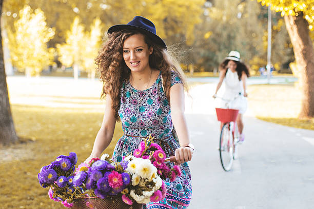Two best friends riding bicycles in a park