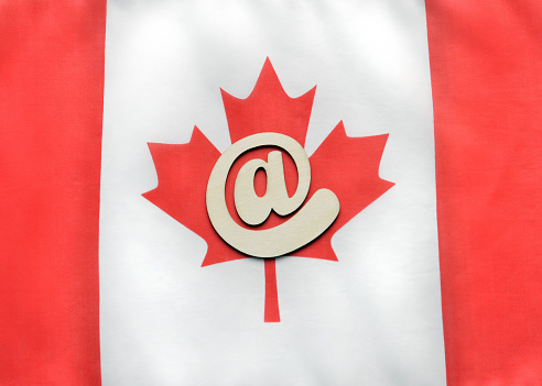 Closeup of an @ symbol on a Canadian Flag. 