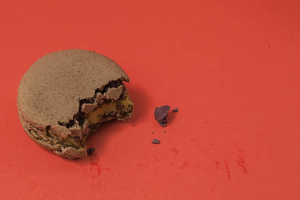 Bitten macaron in red pastel isolated background