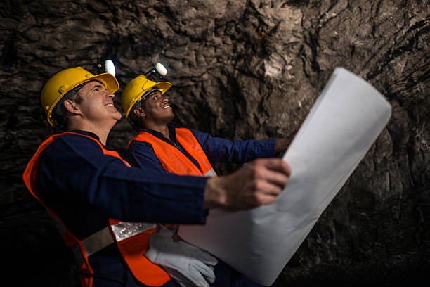 istock Miners working at the mine holding a blueprint 491348360