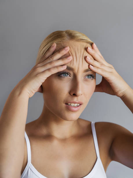 Oh no, I've got wrinkles! Young woman shrinking her forehead with worried expression on her face. wrinkled forehead stock pictures, royalty-free photos & images