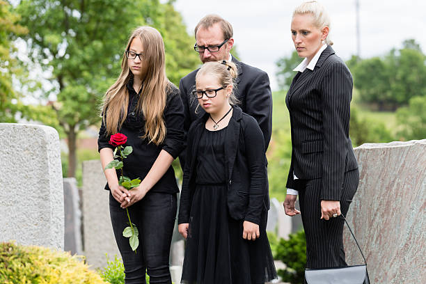istock Family on cemetery mourning deceased relative 491352246
