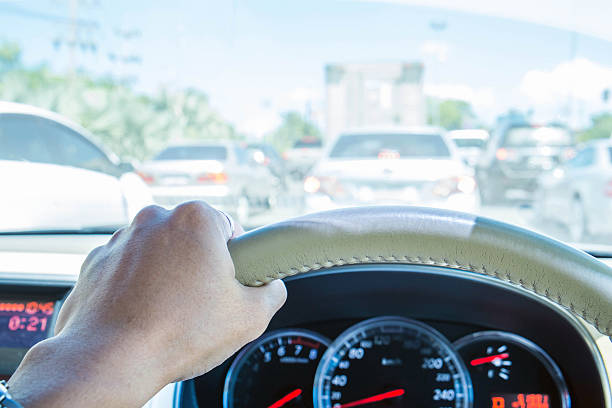 Hand of driver holding steering, with wheel traffic view