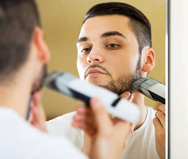 istock guy shaving by electric shaver 491361040