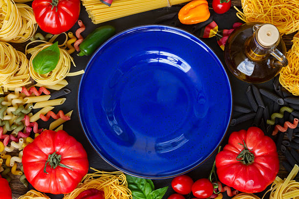 istock Raw pasta with ingridients and blue plate 491361158