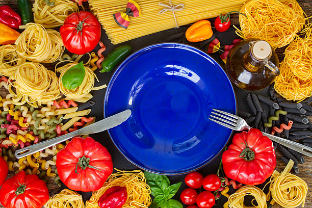 istock Raw pasta with ingridients and blue plate 491361172