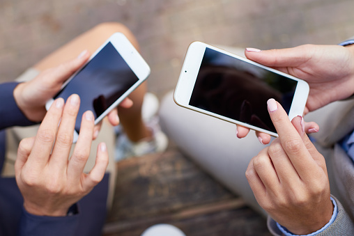 Businesswoman holding smartphone and preparing to touch screen