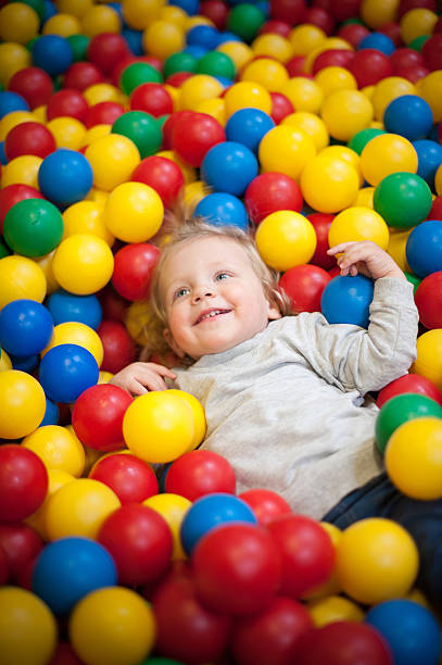 Young girl playing in a ball pool stock photo