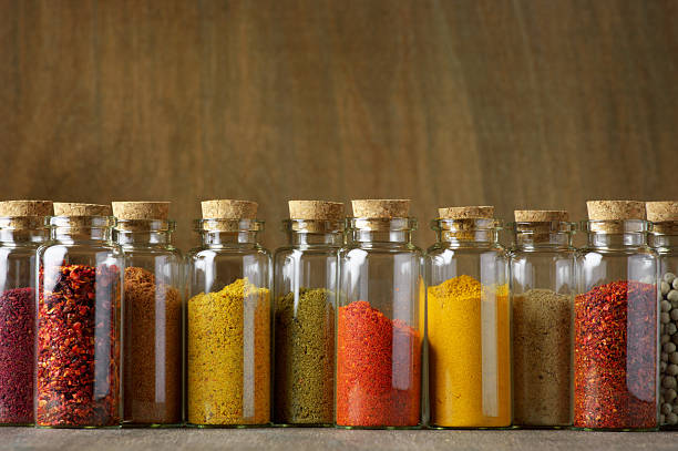 Spices in bottles Assorted ground spices in bottles on wooden background. seasoning stock pictures, royalty-free photos & images