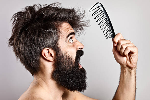 istock Bearded man with messy hair goggling at a warped comb 491375739