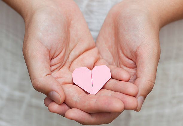 istock Origami heart in human hands 491375977