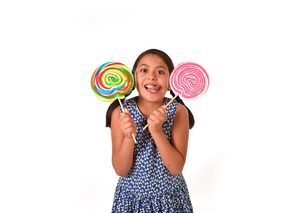 istock latin child holding two big lollipop  in sugar addiction concept 491376162