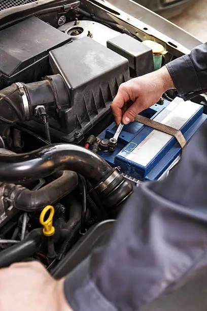 Fitting a battery to a car in a garage, Close-up