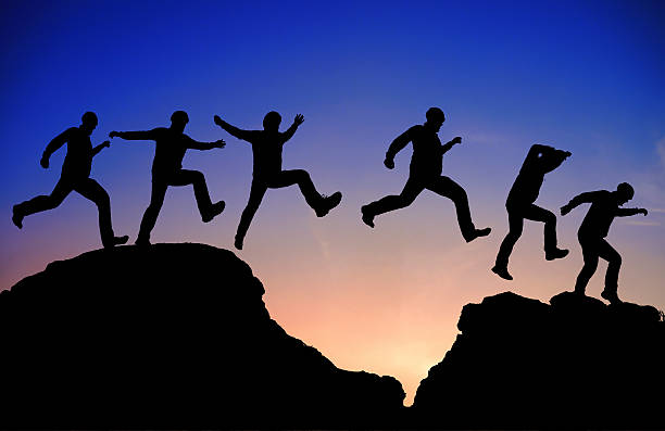 istock Silhouette of a man jumping over a rock 491376595