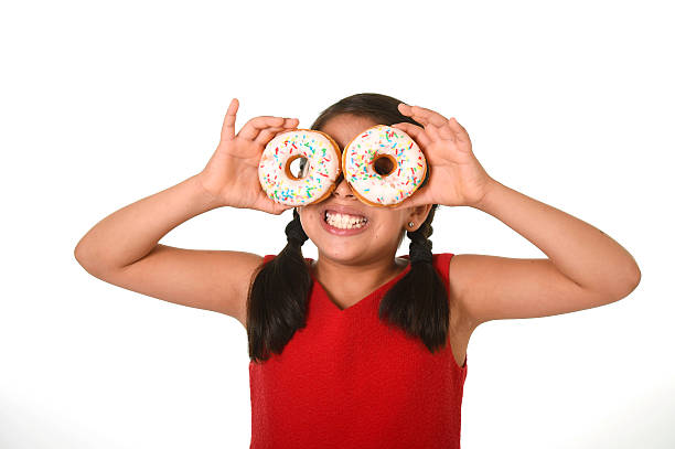 istock latin child playing with donuts in face as cake eyes 491377460