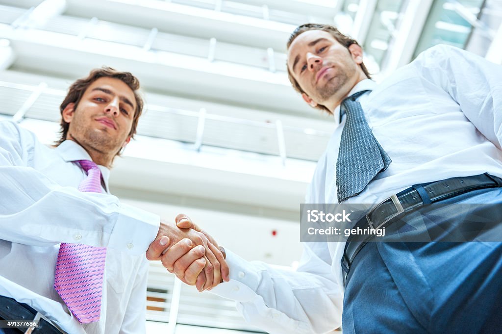 Colleagues shaking hands in office Closeup of  shaking hands in office Achievement Stock Photo