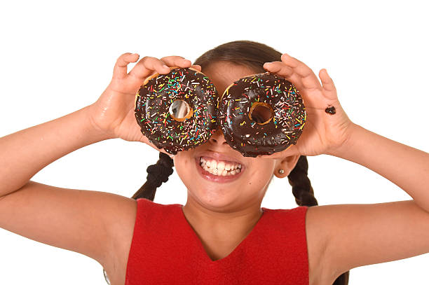 istock latin child playing with donuts in face as cake eyes 491377724