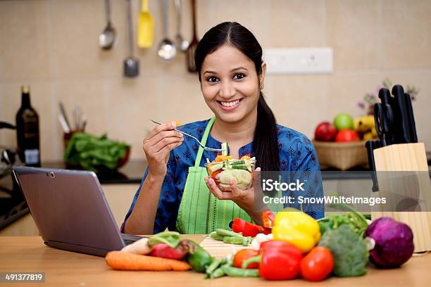 Smiling Woman With Kitchen Apron And Eating Salad Stock Photo - Download Image Now - Healthy Eating, Women, Eating