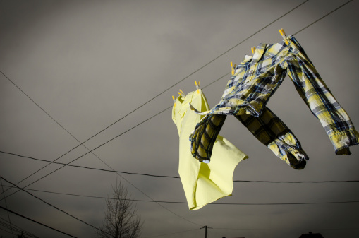 Image of two shirts hang drying on a line with stormy weather