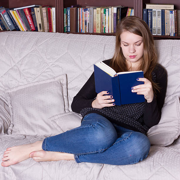 istock Woman at the library reading book 491379494