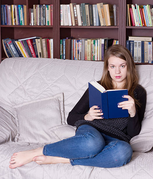istock Woman at the library reading book 491379532
