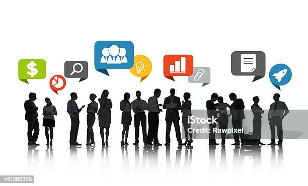 Group Of Business People Talking And Business Related Symbols Stock Photo - Download Image Now