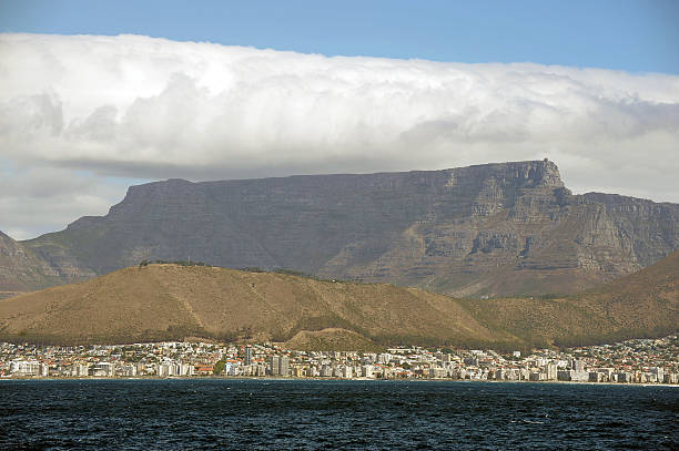 Table Mountain from the sea,S.Africa Blue sky over Capetown and Table Mountain seen from the ocean as the 'table cloth' of cloud starts to settle; Capetown, S.Africa table mountain and the tablecloth stock pictures, royalty-free photos & images