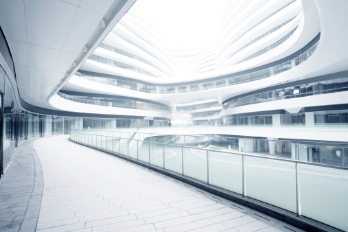 Office building lobby hall blur background or blurry school hallway corridor interior view looking toward empty corridor entrance, glass curtain wall and floor with exterior light illumination