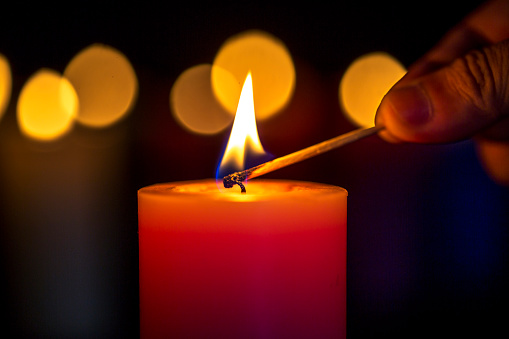 lighting candle with match