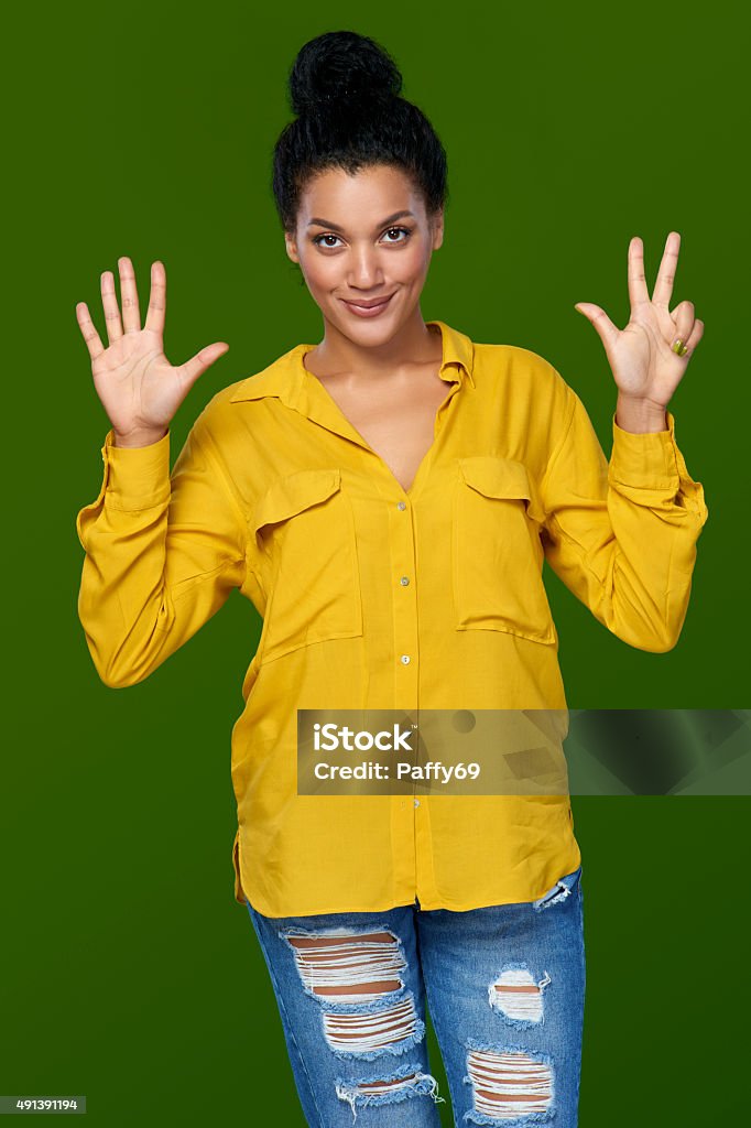 Woman showing eight fingers Hand counting - eight fingers. Happy mixed race african american - caucasian woman indicating the number eight with her fingers 2015 Stock Photo