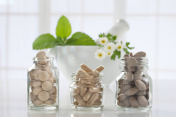 istock Herbal medicine pills and mortar over bright  background 491395430